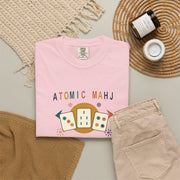 Folded blossom pink Atomic Mahj Comfort Colors shirt showing the retro Mahjong tile print in a styled product view.